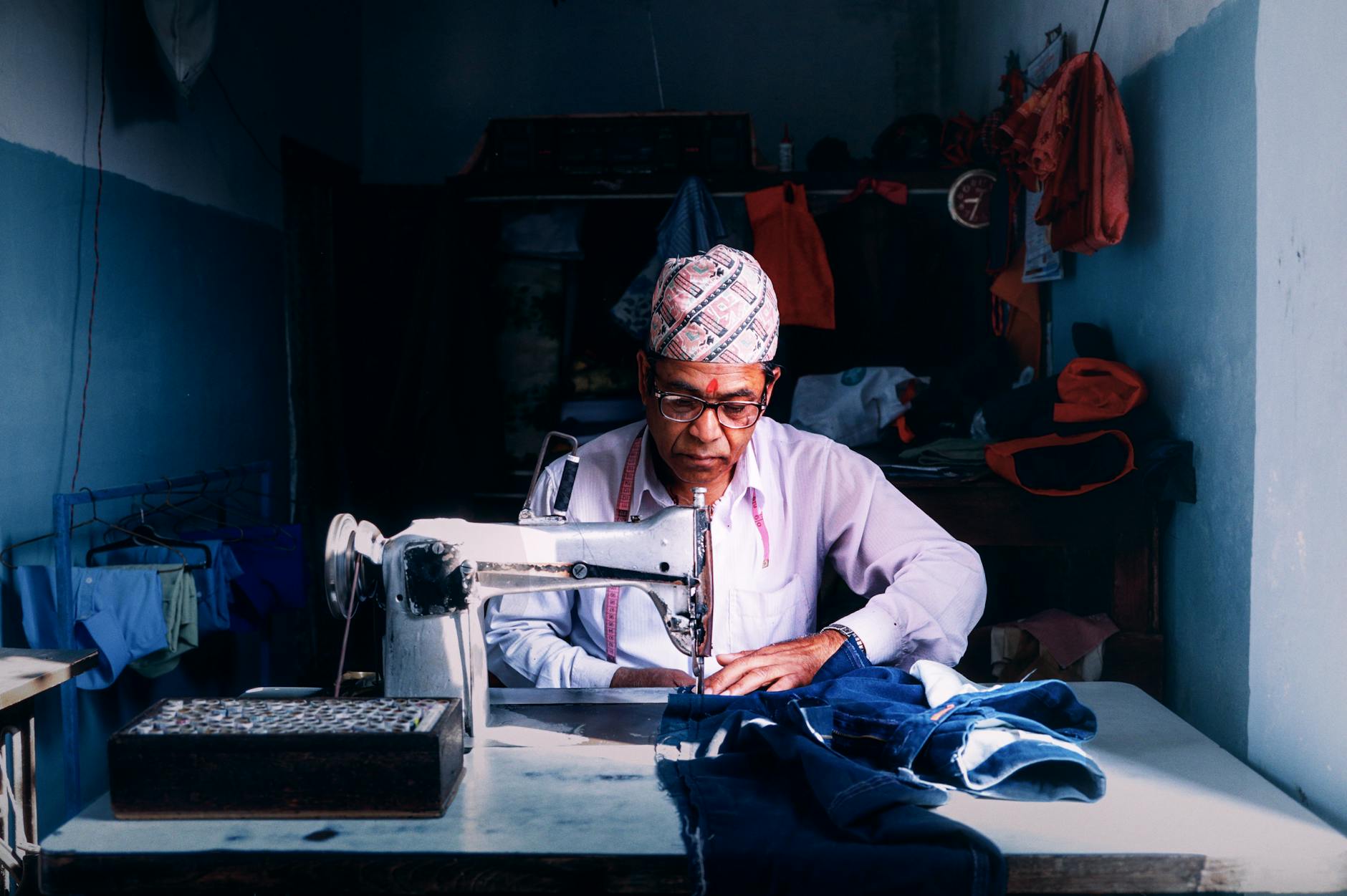 Krawiec przy maszynie do szycia w tradycyjnej pracowni