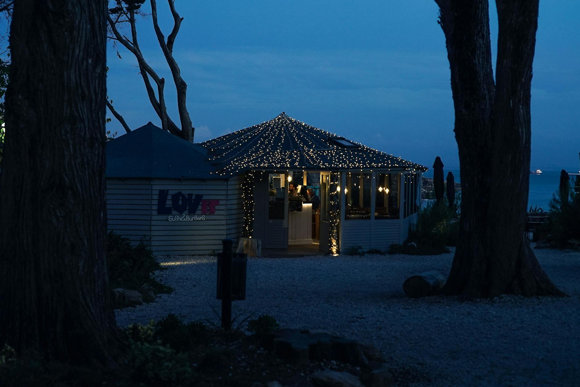 Nastrojowa nadmorska restauracja z girlandami świateł wieczorem