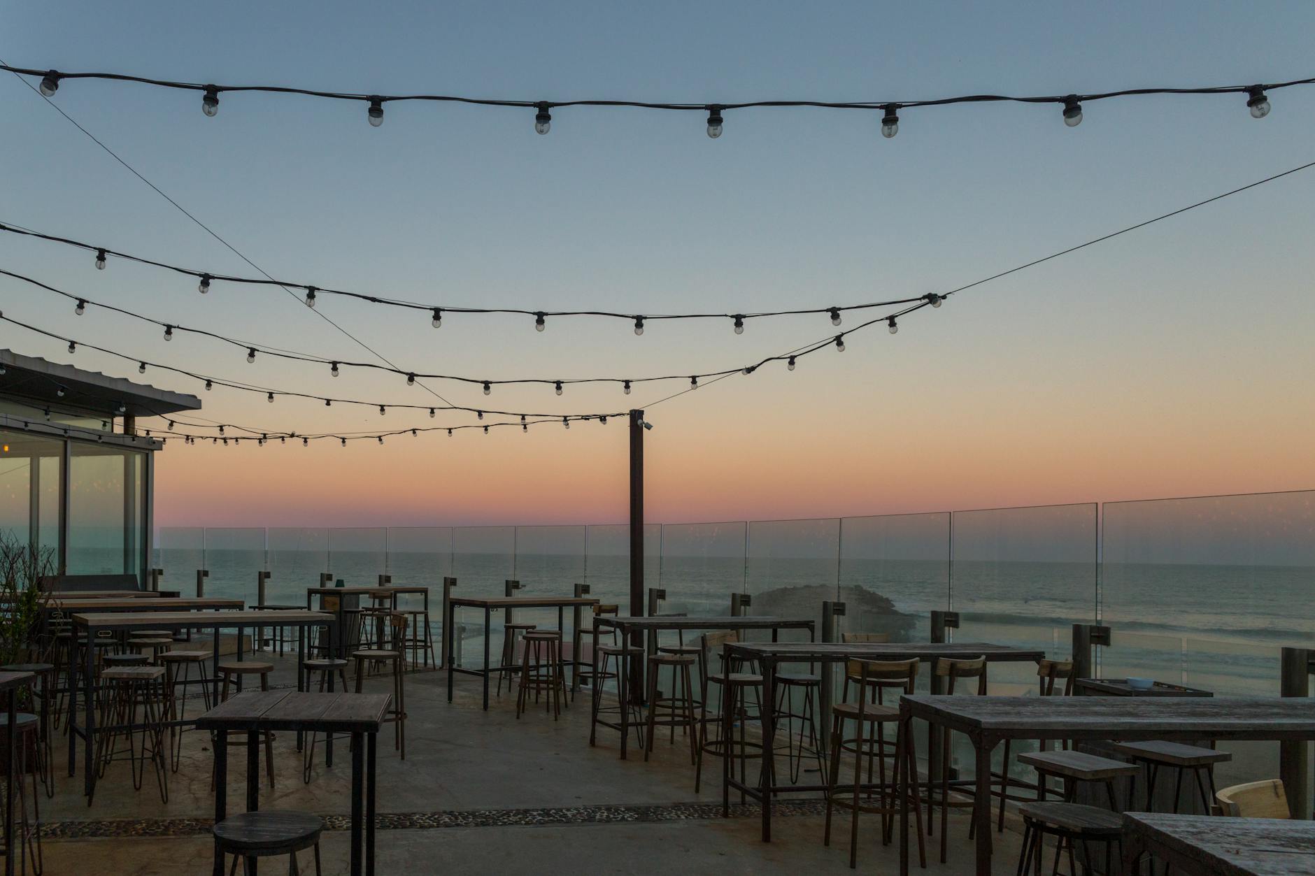 Pusta tarasowa restauracja z widokiem na morze o zachodzie słońca