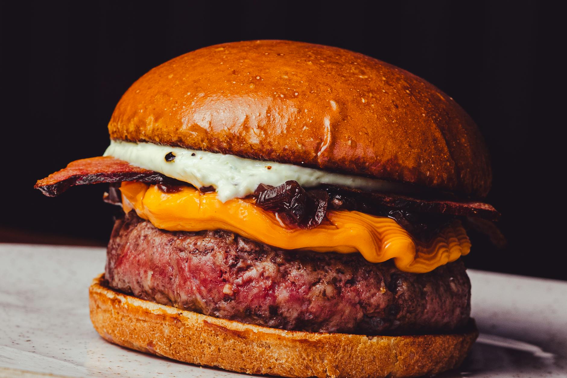 Zbliżenie na burgera premium z bekonem i cheddarem w kołobrzeskiej restauracji