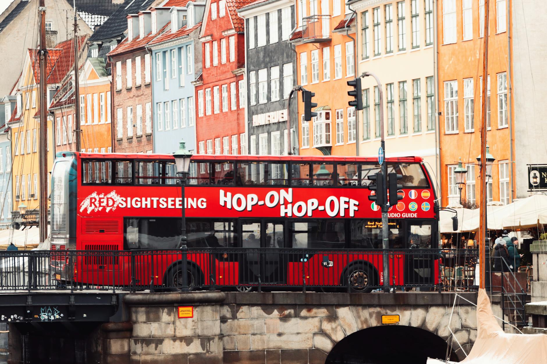 Czerwony autobus turystyczny nad kolorowym kanałem Nyhavn w Kopenhadze