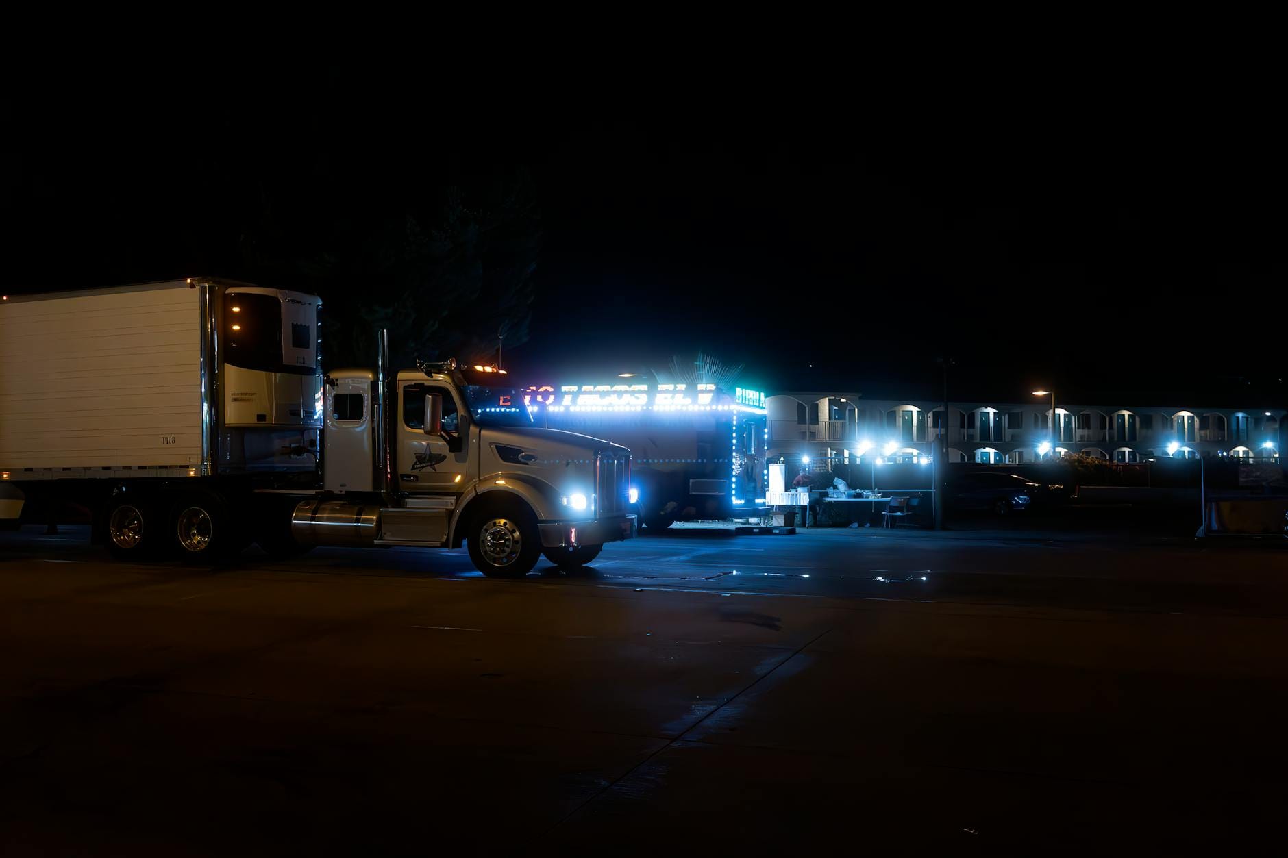 Dojazd w nocy do Grzybowa: oświetlone trasy, stacje i bezpieczne parkowanie Dwa jasno oświetlone ciężarówki zaparkowane nocą przy miejskiej ulicy