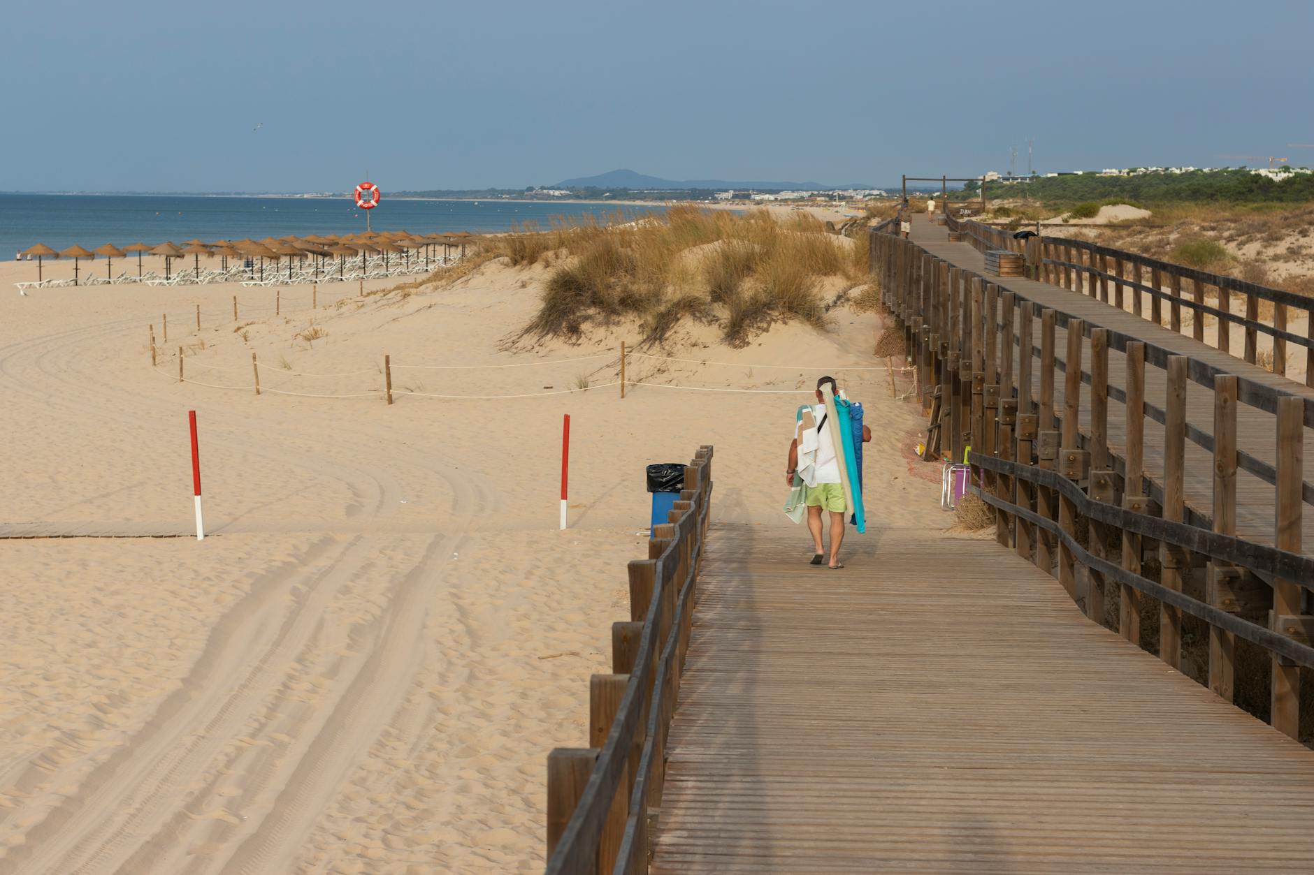 Spacer po Dźwirzynie: trasa od plaży do kanału i najlepsze miejsca na przystanek Drewniany deptak na piaszczystej plaży nad morzem o zachodzie słońca