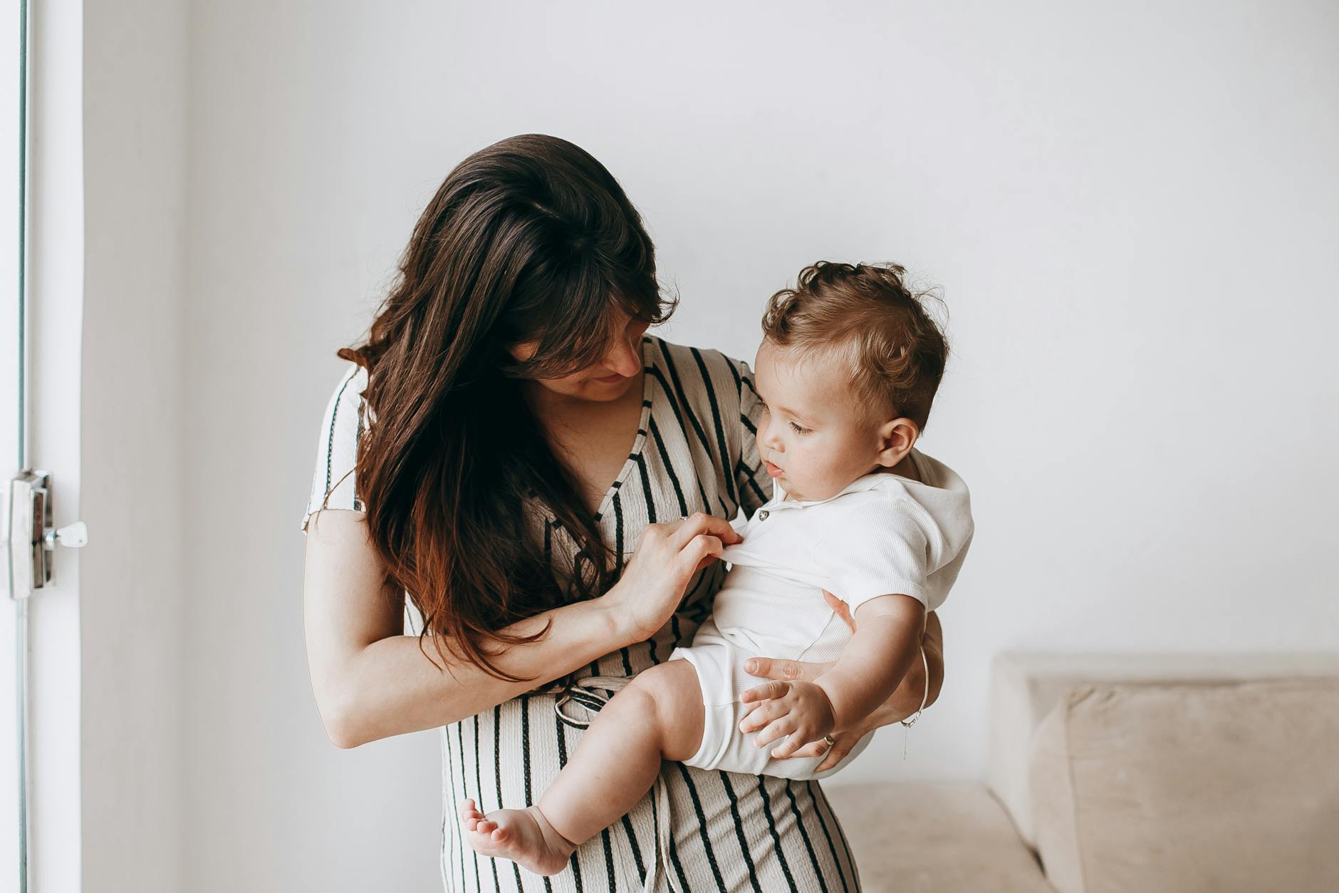 Mama tuląca niemowlę w domu podczas czułej rozmowy