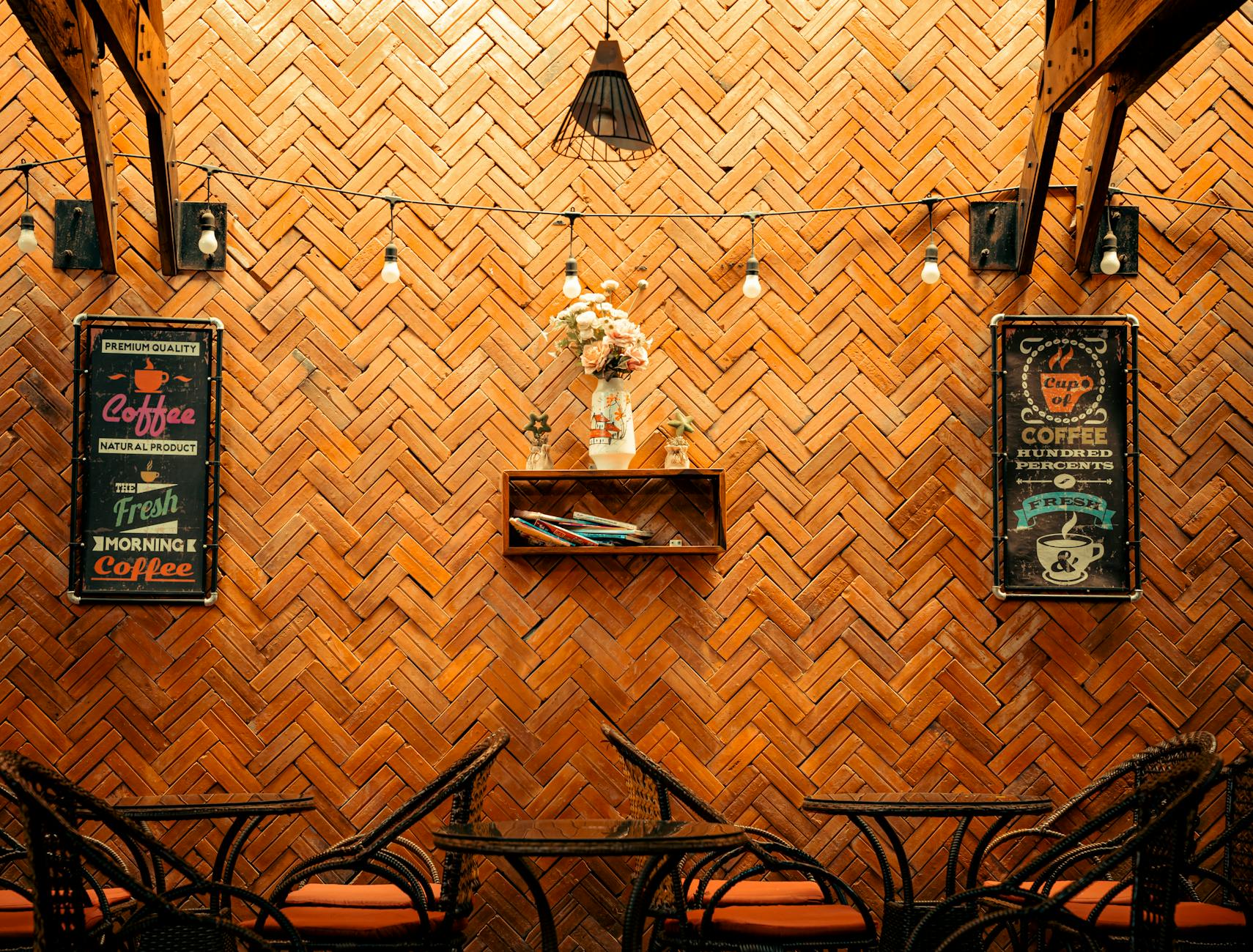 Przytulne wnętrze kawiarni z ceglaną ścianą i starymi szyldami kawy