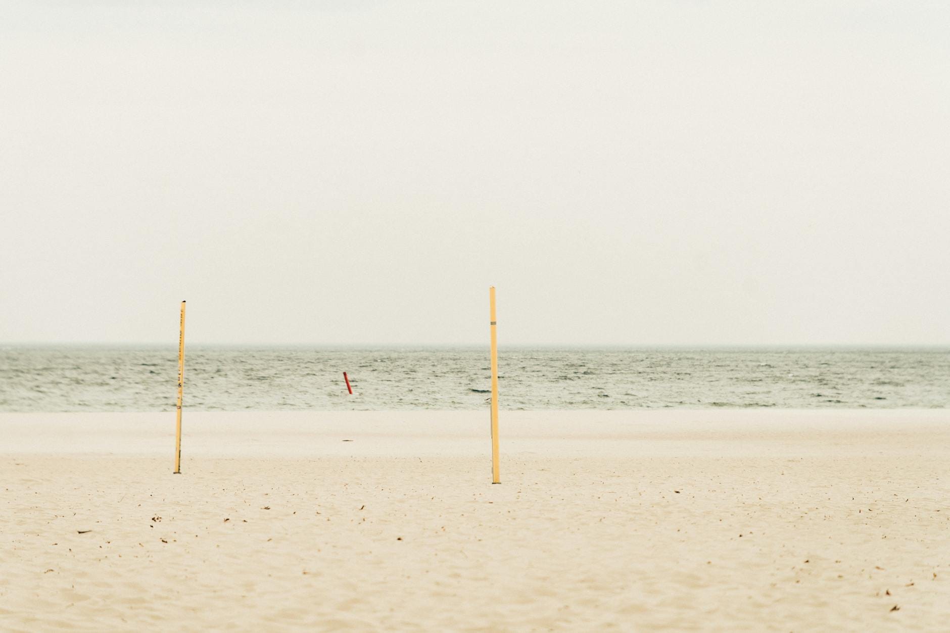 Pusta, spokojna plaża nad Bałtykiem pod pochmurnym niebem