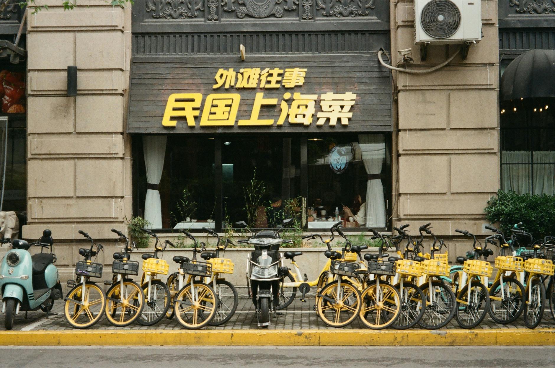 Rowery i hulajnogi zaparkowane przed restauracją w tętniącym życiem mieście