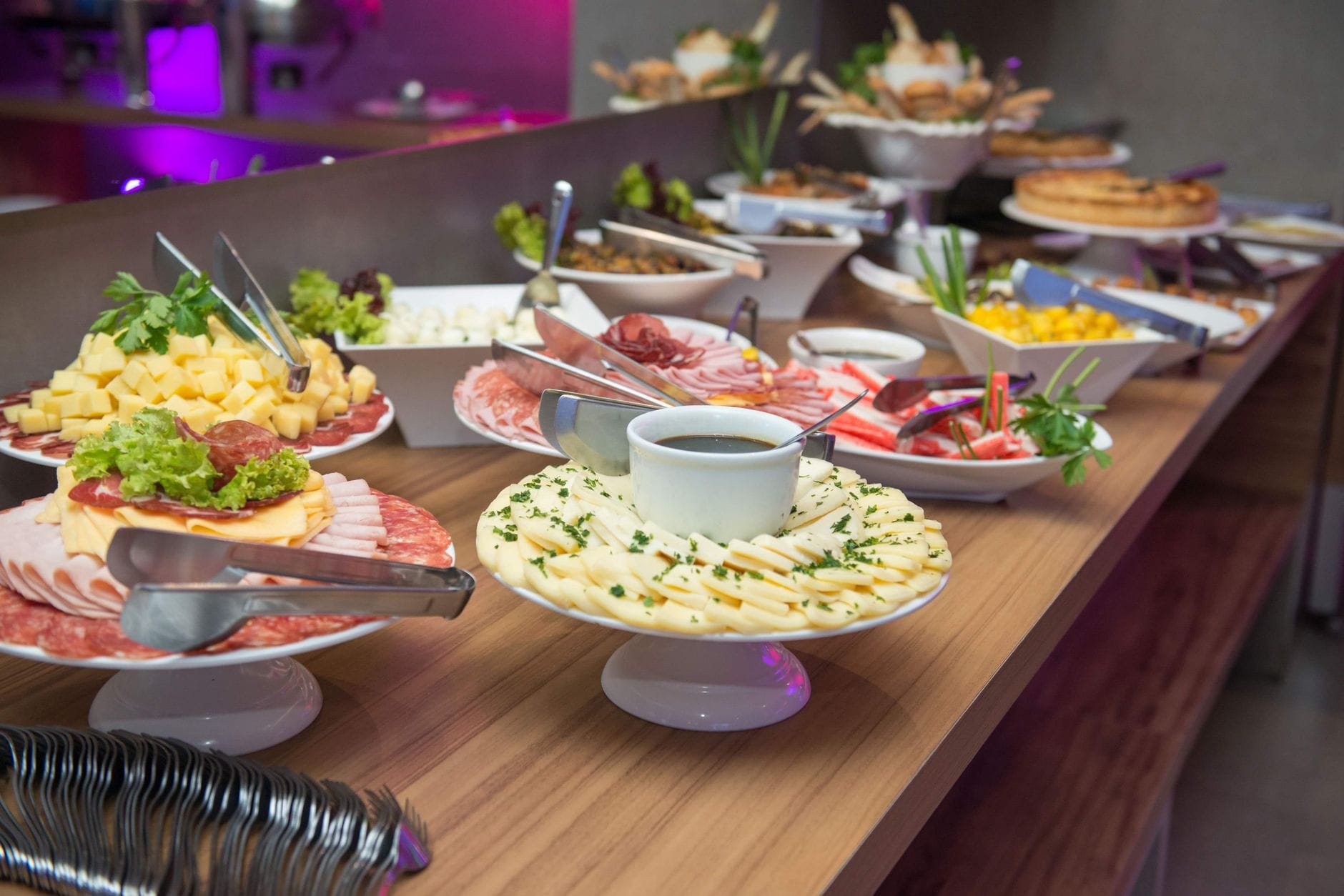 Bufet z różnorodnymi daniami na drewnianym stole w restauracji