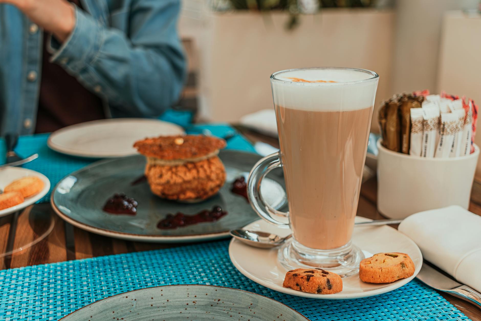 Latte i francuskie wypieki na drewnianym stoliku w przytulnej kawiarni