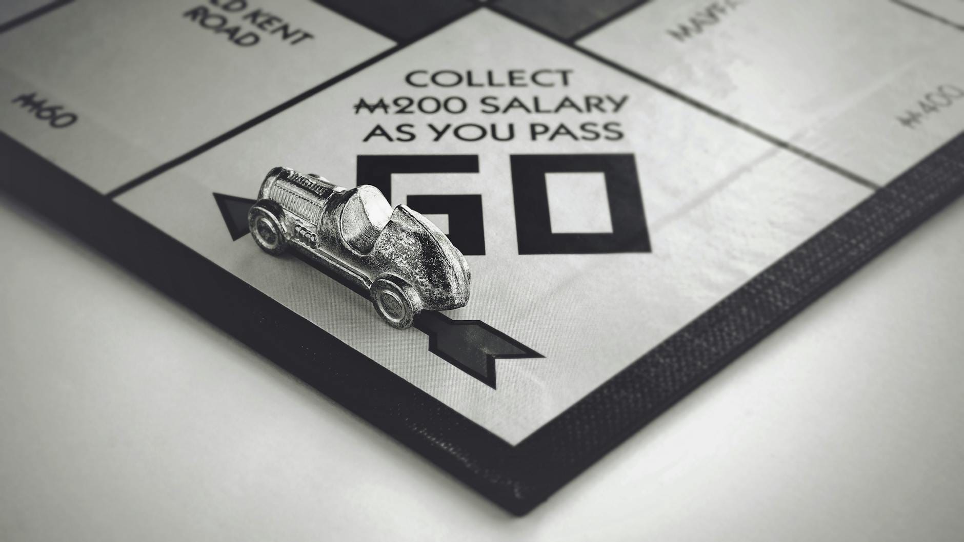 Metalowy samochodzik z Monopoly na planszy, czarno-białe zbliżenie