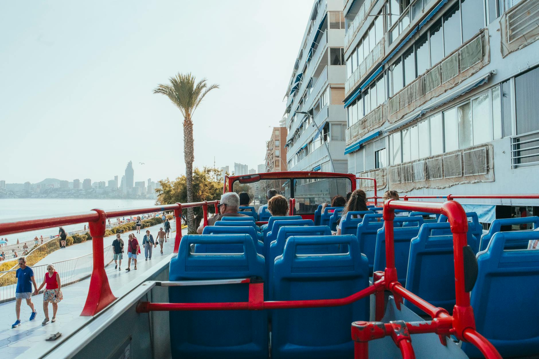 Turyści w piętrowym autobusie wycieczkowym jadącym wzdłuż plaży