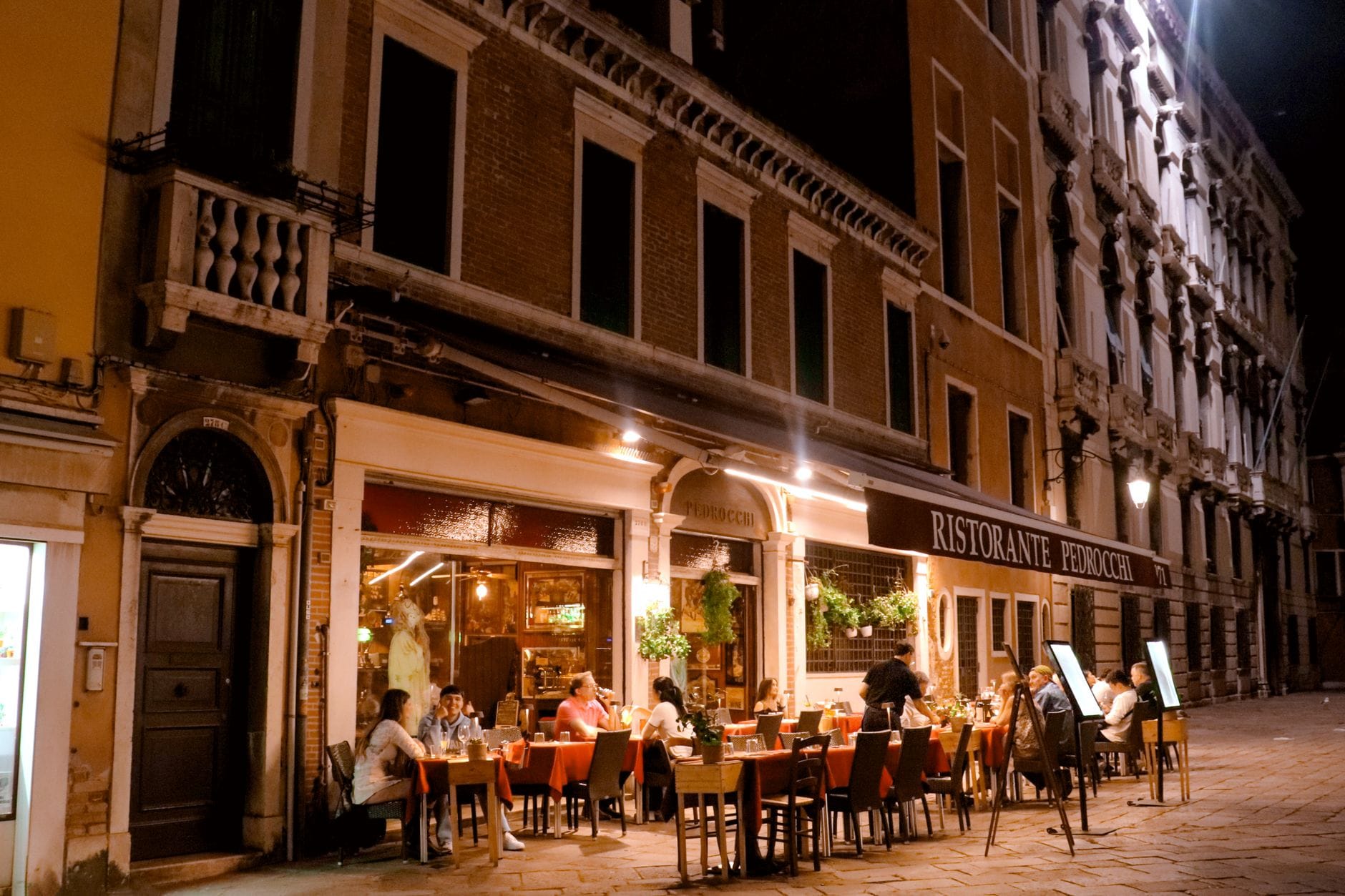 Goście jedzą kolację w nastrojowej restauracji wieczorem